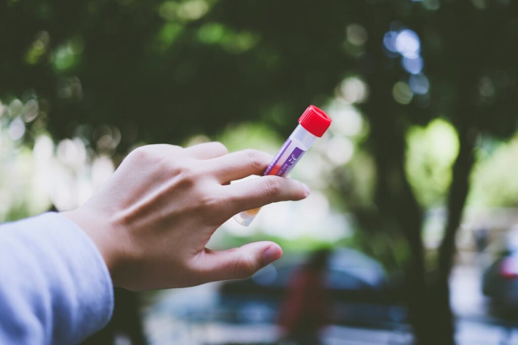 Zinc Supplementation and Immune Function: How to Test Adequacy a person holding a small red and white tube